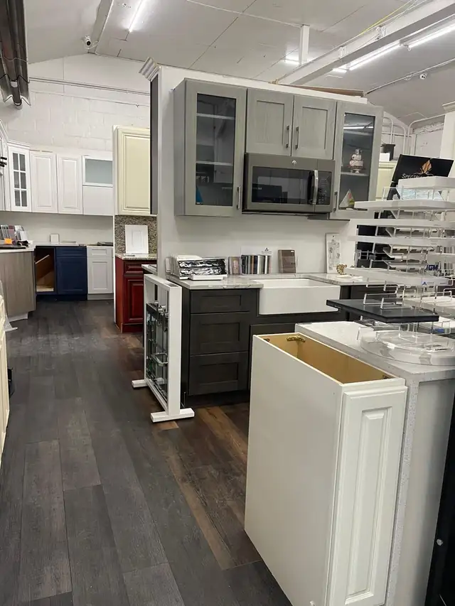 Elizabeth Kitchen & Granite showroom with grey, espresso, navy, white and red cabinet displays and stone sample racks